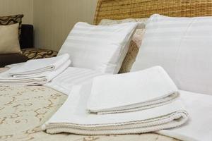 Bath towels and pillows on the bed in Interior of the modern bedroom in loft flat apartments in light color style photo