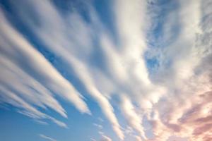 Blue sky background with tiny curly striped clouds in the evening. Clearing day and Good windy weather photo