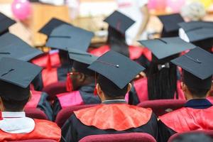 Foreign medical students in square academic graduation caps and black raincoats during commencement photo