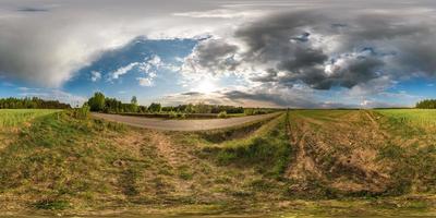 Full spherical seamless panorama 360 degrees angle view on no traffic asphalt road among alley and fields with awesome clouds in equirectangular equidistant projection, VR AR content photo