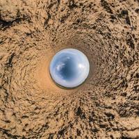 Little planet transformation of spherical panorama 360 degrees. Spherical abstract aerial view in field with awesome beautiful clouds. Curvature of space. photo