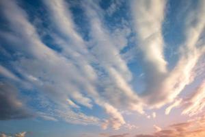 fondo de cielo azul con diminutas nubes de rayas rizadas por la noche. día despejado y buen tiempo ventoso foto