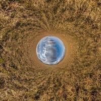 bola de cielo azul en medio del campo giratorio. inversión de la transformación del pequeño planeta del panorama esférico de 360 grados. curvatura del espacio. foto