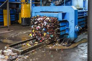 recolección de basura por separado. equipo para prensar material de clasificación de escombros para ser procesado en una moderna planta de reciclaje de residuos. foto