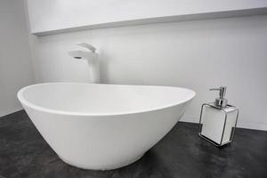 Soap and shampoo dispensers near Ceramic Water tap sink with faucet in expensive loft bathroom photo