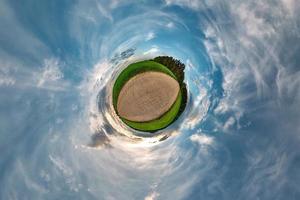 pequeño planeta transformación de panorama esférico 360 grados. vista aérea abstracta esférica en el campo en una agradable velada con impresionantes nubes hermosas. curvatura del espacio. foto