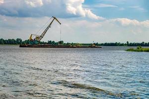 huge digger in quarry  for sand extraction mining in lake photo