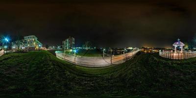 Panorama nocturno esférico sin costuras Vista en ángulo de 360 grados en el casco antiguo de la calle cerca del puente con faros de camión en proyección equirectangular, contenido de realidad virtual listo vr ar foto