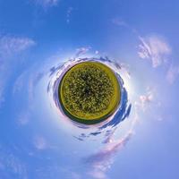 Little planet transformation of spherical panorama 360 degrees. Spherical abstract aerial view in field with awesome beautiful clouds. Curvature of space. photo