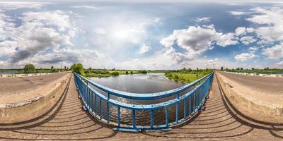 panorama hdri esférico completo sin costuras vista en ángulo de 360 grados en un puente de hormigón cerca de una carretera asfaltada que cruza el río en un día soleado de verano en proyección equirectangular, contenido de realidad virtual ar vr foto