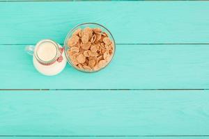 Milk, cookie, oat flakes. Breakfast and pink rose on blue wooden background and lace napkin. Top view and copy space. Mothers day. photo