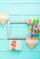 Romantic frame with copy space and accessories on blue wooden background. Top view photo