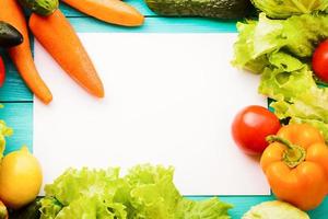 Different vegetables on kitchen table with recipe list and copy space. Top view photo