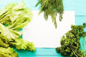 Parsley and recipe paper on blue wooden kitchen table. Top view photo