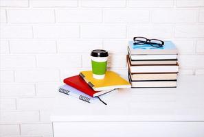 Education literature and notebooks with accessories on workplace near brick wall. Top view and selective focus. photo