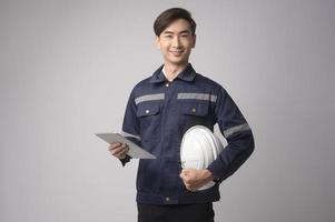 retrato de un ingeniero que lleva un casco protector sobre un estudio de fondo blanco. foto