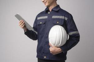 retrato de un ingeniero que lleva un casco protector sobre un estudio de fondo blanco. foto