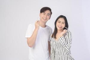 Young smiling man amd woman holding invisalign braces over white background studio, dental healthcare and Orthodontic concept. photo