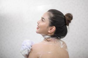 Happy beautiful woman is taking a shower photo