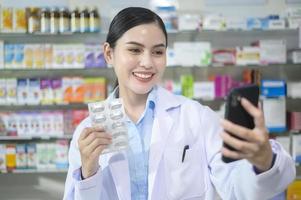 una farmacéutica que asesora a una clienta a través de una videollamada en una farmacia moderna. foto