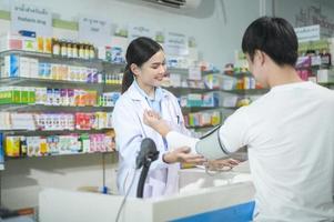 Una farmacéutica que asesora a una cliente sobre el uso de medicamentos en una farmacia moderna. foto