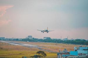 Ho Chi Minh city, Vietnam - FEB 12 2022 Airplane fly over urban areas preparing landing into Tan Son Nhat International Airport and takes off in TSN airport photo