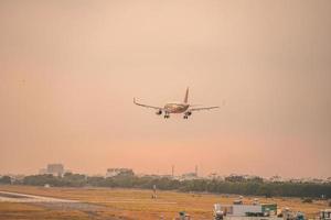 Ho Chi Minh city, Vietnam - FEB 12 2022 Airplane fly over urban areas preparing landing into Tan Son Nhat International Airport and takes off in TSN airport photo