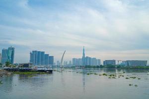 ciudad de ho chi minh, vietnam - 12 de febrero de 2022 horizonte con el emblemático rascacielos 81, se está construyendo un nuevo puente atirantado que conecta la península de thu thiem y el distrito 1 a través del río saigon. foto