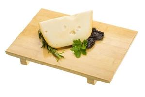 Maasdam cheese on wooden plate and white background photo