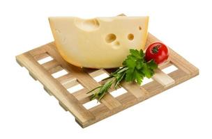 Maasdam cheese on wooden plate and white background photo