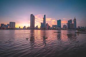 ho chi minh, vietnam - 13 de febrero de 2022 vista del edificio de la torre financiera bitexco, edificios, carreteras, puente thu thiem y río saigon en la ciudad de ho chi minh al atardecer. imagen panorámica de alta calidad. foto