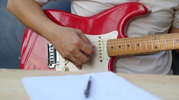 Man composing song using his guitar video