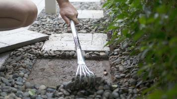 el jardinero está trabajando con la decoración del suelo del jardín doméstico utilizando losas de hormigón y material de piedra