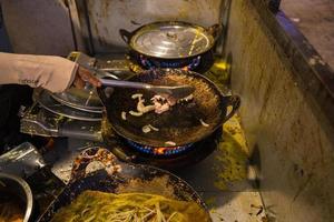 crepes vietnamitas banh xeo rellenos con carne de cerdo o pollo también, camarones, cebollas y brotes de soja, y salsa picante colocada cerca del plato sobre la mesa foto