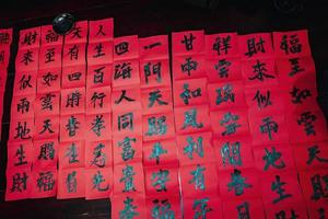 Vietnamese scholar writes calligraphy at Long Son. Calligraphy festival is a popular tradition during Tet holiday. Writing couplets for Spring Festival, new year. photo