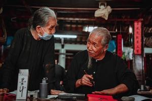 Vietnamese scholar writes calligraphy at Long Son. Calligraphy festival is a popular tradition during Tet holiday. Writing couplets for Spring Festival, new year. photo