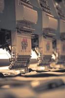 Modern and automatic high technology sewing machine for textile or clothing apparel making manufacturing process in industrial. Digital textile industry. Computerized embroidery. photo