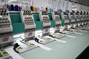 máquina de coser moderna y automática de alta tecnología para el proceso de fabricación de prendas de vestir o textiles en la industria. industria textil digital. bordado computarizado. foto