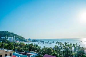 Vung Tau city aerial view with beautiful sunset and so many boats. Panoramic coastal Vung Tau view from above, with waves, coastline, streets, coconut trees and Tao Phung mountain in Vietnam. photo