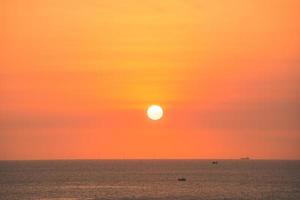 hermoso paisaje de playa al atardecer, naturaleza exótica de la isla tropical, cielo amarillo rojo colorido, barco de silueta, reflejo dorado del sol, vacaciones de verano. cielo nube cinemática. foto