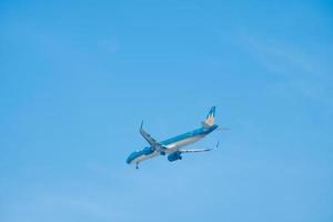 Ho Chi Minh city, Vietnam - FEB 13 2022 Vietnam Airlines fly over urban areas preparing landing into Tan Son Nhat International Airport and takes off in Ho Chi Minh City, Vietnam. photo