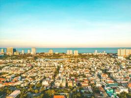 Vung Tau city aerial view with beautiful sunset and so many boats. Panoramic coastal Vung Tau view from above, with waves, coastline, streets, coconut trees and Tao Phung mountain in Vietnam. photo