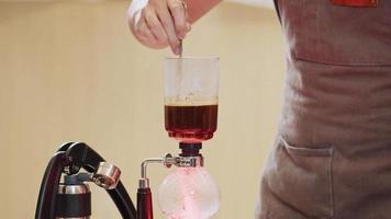 Professional baristas making coffee like a Siphon Coffee Maker. 4k Slow Motion video  The submitted footage is a grouping shooting arrangement
