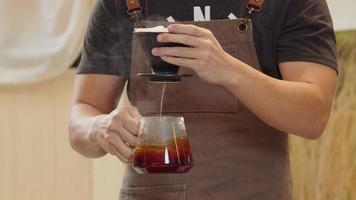 un barista professionnel verse de l'eau sur le marc de café dans le filtre comme un processus manuel. cu shot, vidéo au ralenti 4k la séquence soumise est un arrangement de prise de vue groupée