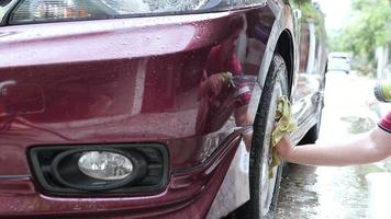 man tvättar bil med schampo och vatten - hemfolk bil rent koncept video