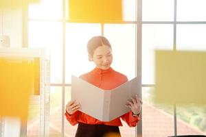 Business woman is reading documents view through window photo