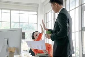 Happy asian business team working together in office photo