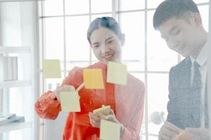 Business people writing ideas on sticky notes photo