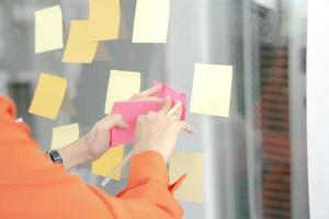 Businesswoman writing on colorful sticky note paper in business office photo