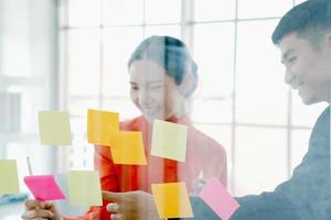 Happy creative people making mind map on a glass wall in the office. photo